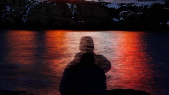 ARCHIVO - En esta fotografía de archivo, tomada con exposición prolongada, se ve la silueta de un hombre frente a luces reflejadas en las aguas de Cape Neddick, el 11 de diciembre de 2017, en Maine. (AP Foto/Robert F. Bukaty, archivo)