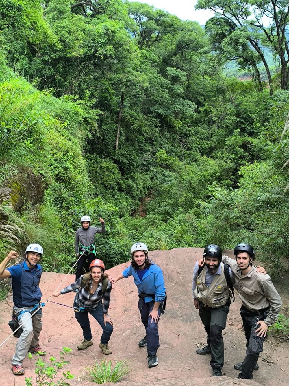 Difícil acceso. El grupo de científicos, y a su izquierda el grupo de rappel Salvaventura de la provincia de Jujuy. Ellos son un equipo especializado en trabajos con cuerdas y rappel, que fueron indispensables para la llegada al sitio y el éxito de la campaña, liderado por Salvador Gómez. Atrás, la exuberante selva de Yungas.