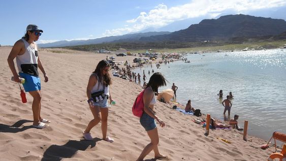 El bajo nivel del dique obliga a los visitantes a caminar desde la ruta para llegar al agua. Algunos se aventuran en sus camionetas hasta la orilla. Foto: Jose Gutierrez