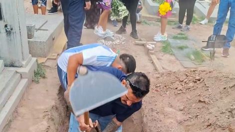 El video muestra cómo los seres queridos cavaban mientras los trabajadores municipales observaban perplejos la situación.