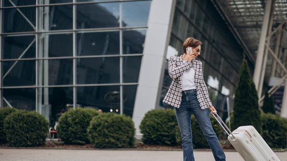 Mujer en un aeropuerto con valija carry on. Equipaje en aeropuertos.