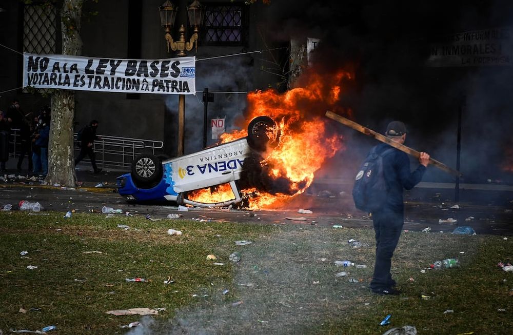 El móvil de Cadena 3 arde durante la protesta cerca del Congreso Nacional, el día en que los senadores debaten el proyecto de reforma económica del presidente argentino Javier Milei, conocido como Ley Bases. Foto NA: REUTERS/Mariana Nedelcu