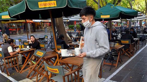 Desde hoy autorizan a Bares y Cafes a abrir sus puertas, y a atender a sus clientes, siguiendo el protocolo contra el Coronavirus.En la foto los empleados de cafes de la Peatonal Sarmiento acomodan y distancias las sillas y mesas a primera hora