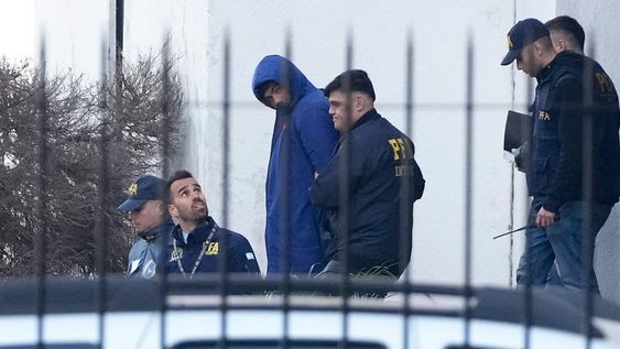 La policía argentina escolta a los jugadores franceses de Rugby Hugo Auradou (al centro) y a Oscar Jegou (fuera de cámara) tras ser arrestados acusados de agresión sexual el jueves 11 de julio del 2024. (AP Foto/Natacha Pisarenko)