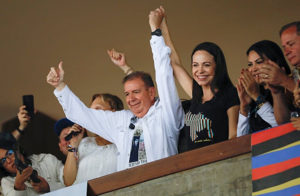 El candidato presidencial de la oposición venezolana Edmundo González, izquierda, y la líder opositora María Corina Machado levantan los brazos durante una reunión con jóvenes en la Universidad Central de Venezuela (UCV) en Caracas, Venezuela, el domingo 14 de julio de 2024. (AP Foto/Cristian Hernández )