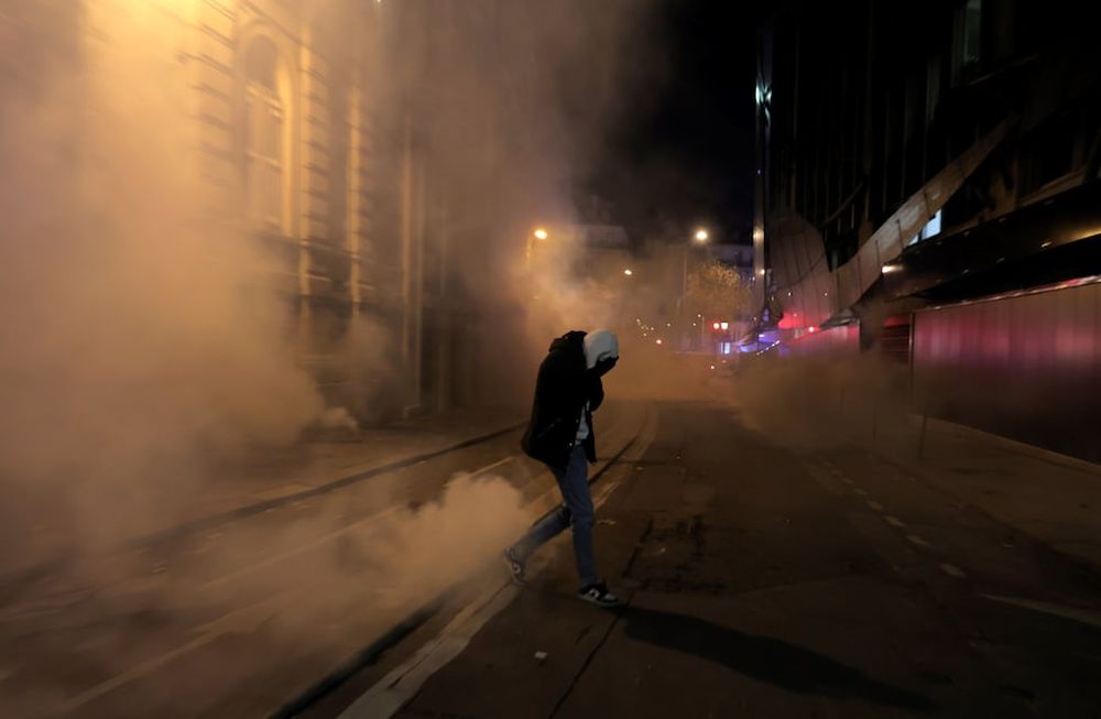 París. Un hincha francés camina entre gas pimienta tras los disturbios por la semifinal del Mundial (AP / Lewis Joly)