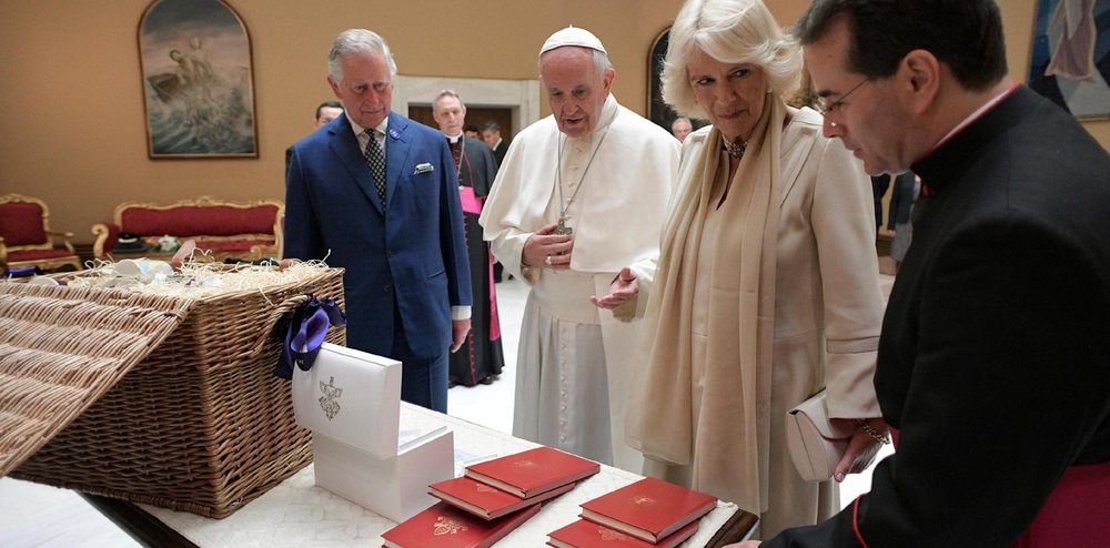 Carlos y Camila intercambian regalos con el papa en una visita que realizaron el entonces príncipe y su esposa al Vaticano en 2017.