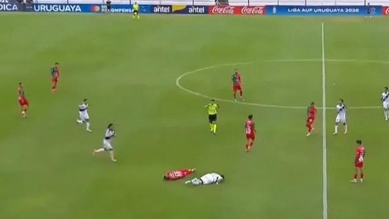 Fútbol. El jugador argentino Ivo Costantino yace en el piso tras golpearse por causalidad con Martín González