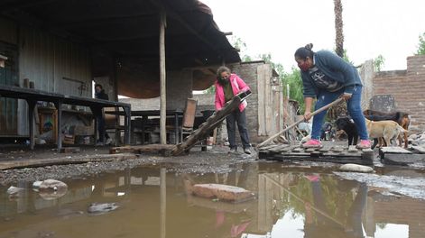 Los Andes | Inundados. Silvia y Ariadna, del merendero Corazones Felices, de El Sauce, Guaymallén, trabajan haciendo canaletas para que  corra el agua en el lugar donde comen los niños almuerzan. Foto: José Gutiérrez / Los Andes.