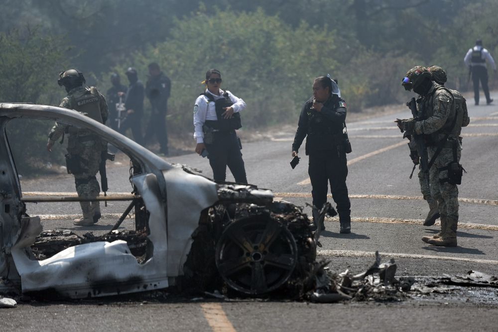 Integrantes de la policía de Morelia y del ejército trabajan en la zona donde fue incendiado un vehículo por presuntos integrantes del crimen organizado este domingo, tras el abatimiento de Nemesio Oseguera Cervantes, alias El Mencho, líder del Cártel Jalisco Nueva Generación (CJNG), en Morelia (México).
