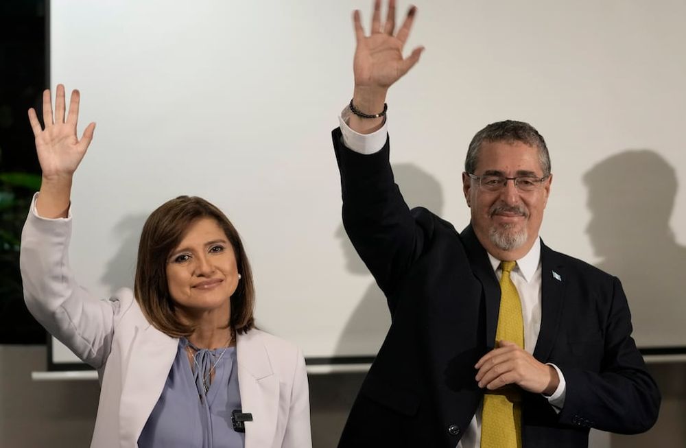 El candidato presidencial Bernardo Arévalo y su compañera de fórmula Karin Herrera saludan durante una conferencia de prensa luego de que los resultados preliminares los mostraran como los vencedores en la segunda vuelta de las elecciones presidenciales en la Ciudad de Guatemala, el domingo 20 de agosto de 2023. (AP Foto/Moisés Castillo)