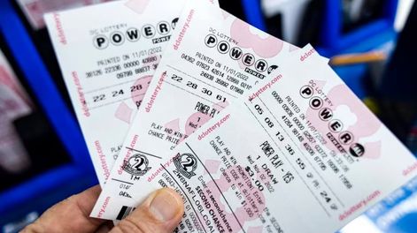 Una persona muestra tickets de la lotería Powerball en Estados Unidos