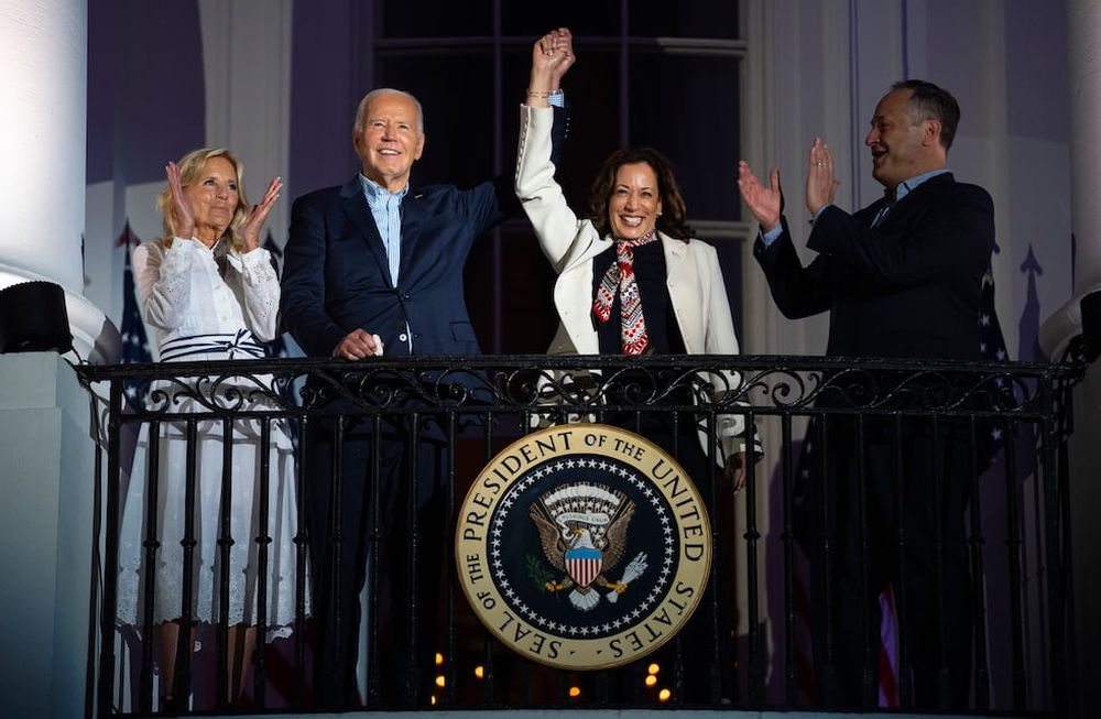 La primera dama Jill Biden y el esposo de Kamala Harris, Douglass Emhoff, observan cómo el presidente Joe Biden le levanta la mano a la vicepresidenta Harris mientras observan el espectáculo de fuegos artificiales del Día de la Independencia en el complejo de monumentos National Mall desde el balcón de la Casa Blanca, el jueves 4 de julio de 2024, en Washington. (AP Foto/Evan Vucci).