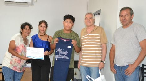Genaro Cueito (centro) recibe una remera. Primera, a la izquierda, su madre Lorena Castro. Al lado de genaro, a la derecha, el delegado municipal de Palmira Ángel Bottero.&nbsp;
