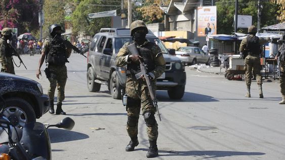 Elementos de la Unidad de Seguridad General del Palacio Nacional de Haití establece un perímetro para retomar el control de una de las tres delegaciones de policía que fueron tomadas por pandillas, en el centro de Puerto Príncipe, Haití, el sábado 9 de marzo de 2024. (AP Foto/Odelyn Joseph)
