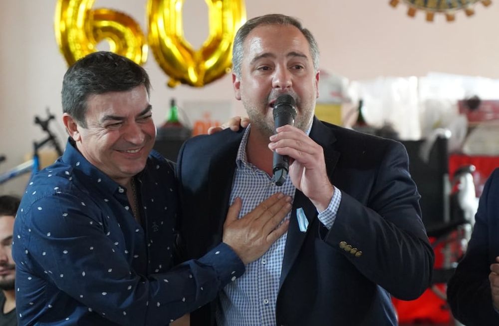 Omar De Marchi y el intendente de Maipú, Matías Stevanato, se abrazan en un acto del Rotary Club de Rodeo del Medio.