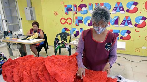 Los Andes | Fiesta Nacional de la Vendimia 2022. Las costureras trabajan en el vestuario, que se usarán para la fiesta mayor de Mendoza. Mirta revisando y apilando  las capuchas rojas. Foto: Orlando Pelichotti / Los Andes