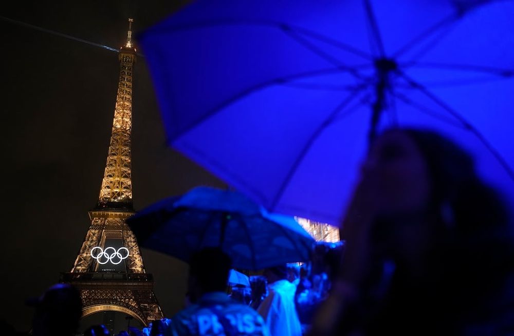 La Torre Eiffel luce iluminada bajo la lluvia el viernes 26 de julio de 2024 durante la inauguración de los Juegos Olímpicos de Verano, en París, Francia. (Foto AP/Natacha Pisarenko)