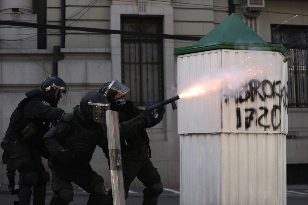 Un integrante de la Policía de Bolivia dispara un arma durante una jornada de protestas que exigen la renuncia del presidente de Bolivia, Rodrigo Paz, este lunes en La Paz (Bolivia).   