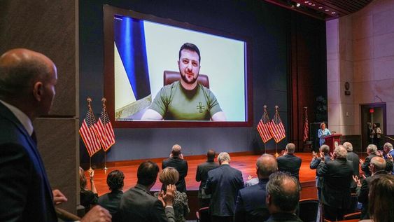 Congresistas  le dan al presidente de Ucrania, Volodymyr Zelensky, una ovación de pie antes de que hable en un discurso virtual en el Auditorio del Congreso del Centro de Visitantes del Capitolio de EE. UU. en Washington.