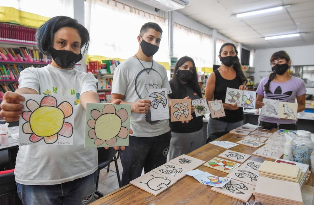 La artista Luisa Olguín junto a quienes la ayudan a montar el futuro mural en Luján, con dibujos de los chicos / Mariana Villa
