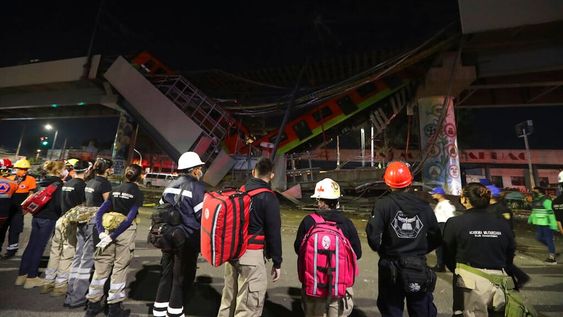 El personal de rescate se detiene frente a los vagones del metro de Ciudad de México tras el derrumbe del puente (AP)