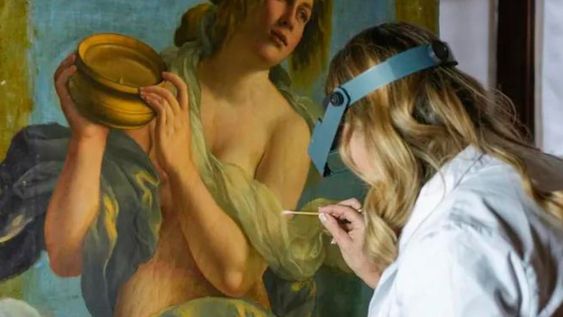 La restauradora Elizabeth Wicks trabaja en la Alegoría de la Inclinación, una obra de 1616 de Artemisia Gentileschi (AP Photo/Andrew Medichini)