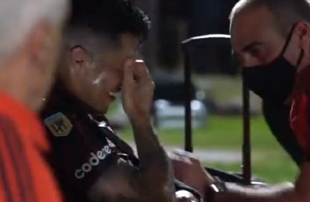 Enzo Pérez y el codo fuera de posición, tras la fuerte caída. El kinesiólogo del equipo lo atiende y trata de animarlo. /Captura de video.