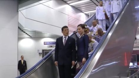 El rey de Tailandia es escoltado por un séquito de personas que deben arrodillarse en una escalera mecánica. Foto Andrew MacGregor Marshall