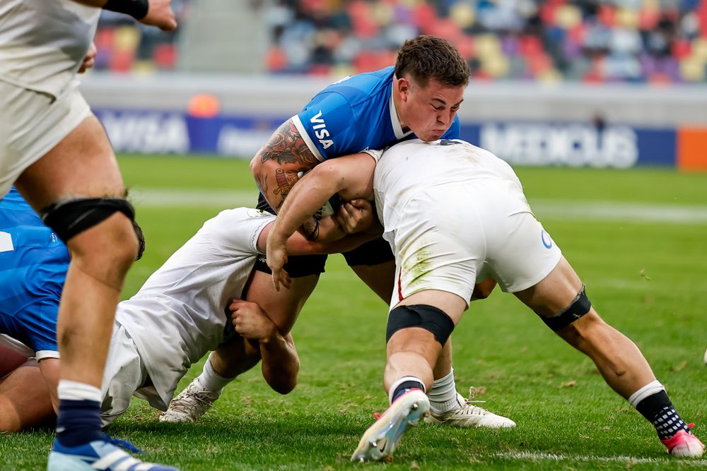 Uno de Los Pumas, Tomas Rapetti lucha contra dos jugadores ingleses que lo taclean