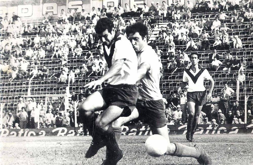 Mario Nogara lleva el balón mientras lo persigue Alfio Coco Basile, más atrás viene Whebe. Fue en el 4-2 de Vélez a Racing en la final del Metropolitano de 1968 en el viejo Gasómetro de Avenida La Plata.