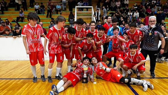 Los campeones del Futsal, de la C 15 de la Escuela San pablo festejan el tricampeonato y muestran su nueva copa de oro.