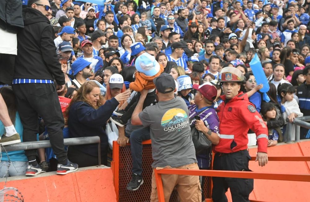 Los hinchas de Godoy Cruz le escapan al gas pimienta que tiró la pelicía en las afueras del estadio para dispersar a la barra / José Gutiérrez.