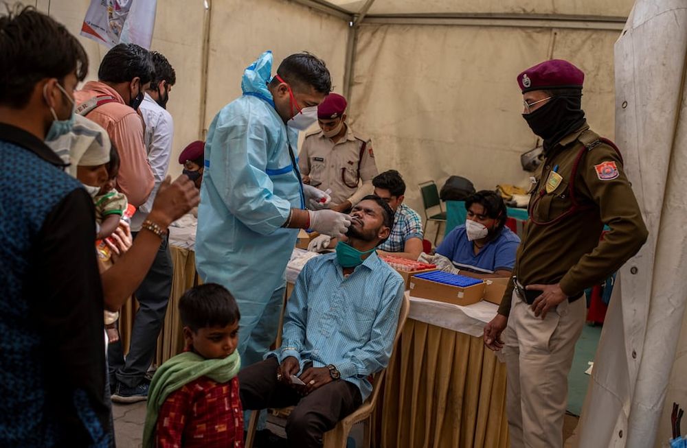 Un trabajador de la salud toma una muestra de hisopado nasal de un pasajero para realizar la prueba de coronavirus en una terminal de autobuses en Nueva Delhi, India. Foto: AP
