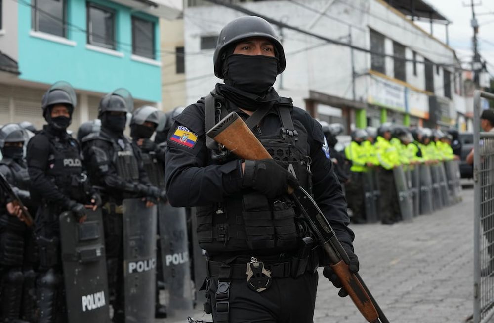 Policías y soldados se encuentran afuera de la prisión El Inca después de que comenzaron los disturbios en el interior en Quito, Ecuador, el lunes 8 de enero de 2024. El motín se produce un día después de que las autoridades ecuatorianas informaron que, en otra prisión diferente en la ciudad de Guayaquil, el líder de la pandilla Los Choneros Adolfo Macías, alias Fito, no se encontraba en su celda. Hace una década, el capo huyó de otra instalación. (Foto AP/Dolores Ochoa)