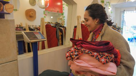 Johana Romero de Yin Bohemian pesa ropa en su local donde tienen la innovadora propuesta de venderla por kilo.