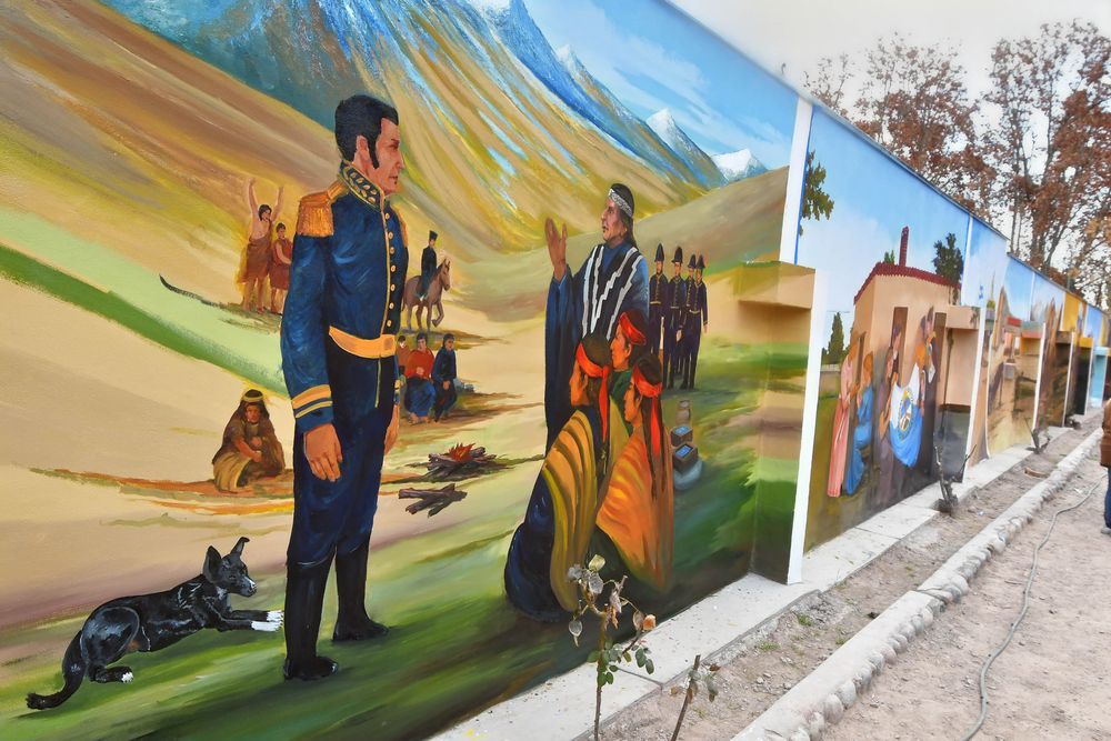 Este paño del mural muestra a San Martín hablando con indios pehuenches en 1816, en el fuerte de San Carlos.  Obsérvese en la escena un perro echado, licencia artística de los autores. Es Flopi, el can de la finca donde se pintó la obra. 