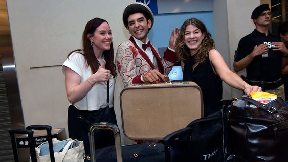 Bajo el cartel de arribos internacionales, un set de actores, ataviados como viajeros de otro tiempo, fueron parte de una peculiar recepción de bienvenida en el aeropuerto. / Foto:  Orlando Pelichotti